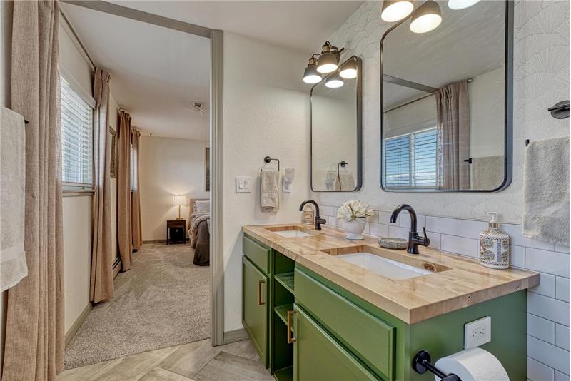 The Primary Bathroom features a dual sink vanity, framed mirrors, and tiled shower.