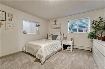 Basement Bedroom #4 has neutral carpet and windows that bring in natural light.