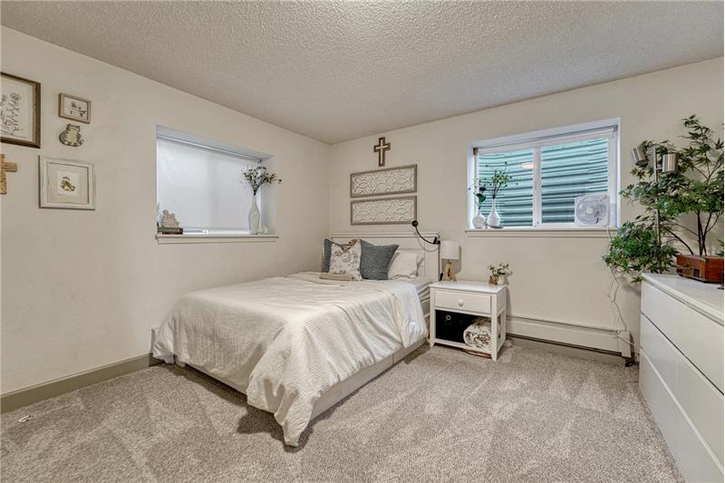 Basement Bedroom #4 has neutral carpet and windows that bring in natural light.