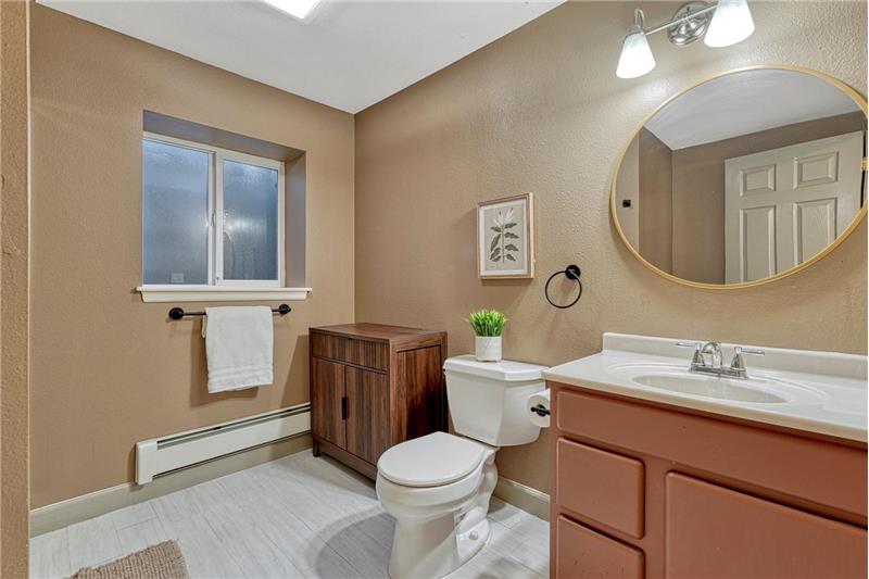 Basement Shower Bathroom with vanity, mirror, and tiled shower.