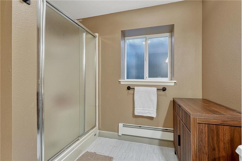 Basement Bathroom with enclosed tiled shower.