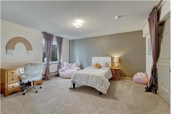 Basement Bedroom #6 has neutral carpets and room for a desk/study area.