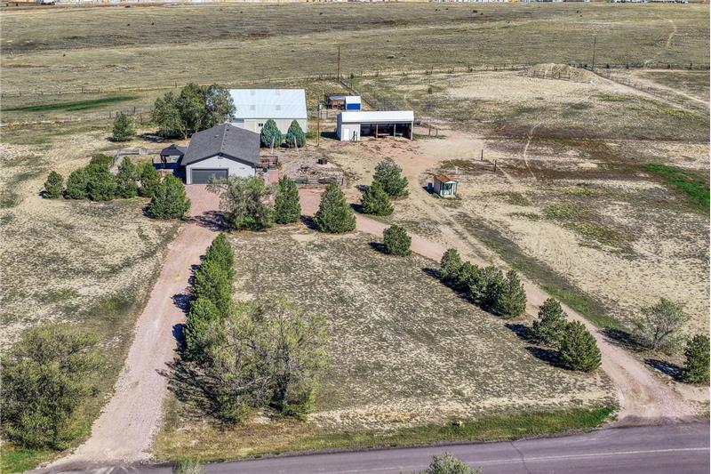 Aerial view of home, outbuildings, and 5.64 acre lot.