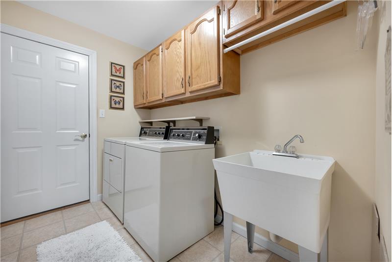 Main floor laundry with cabinets and laundry sink. Door to the garage. Washer and Dryer are included.