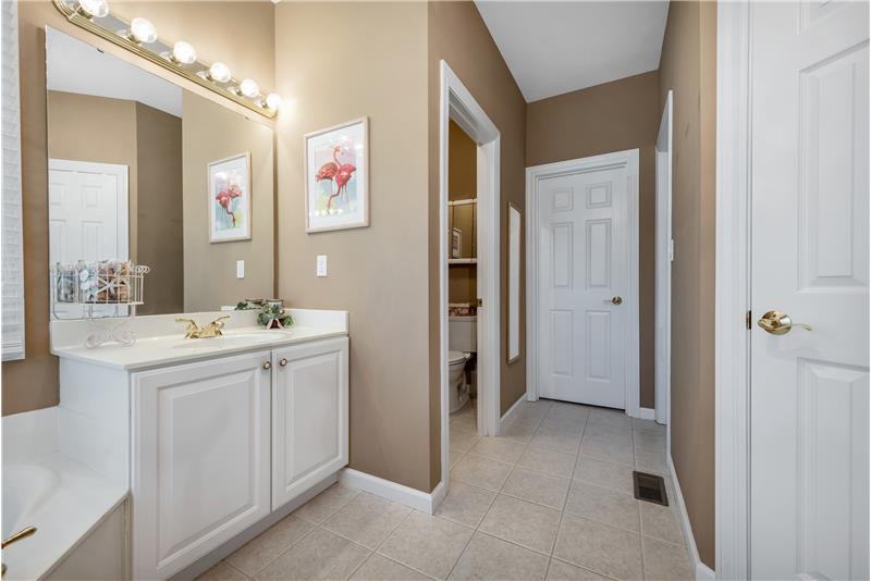 Primary bath water closet with door.