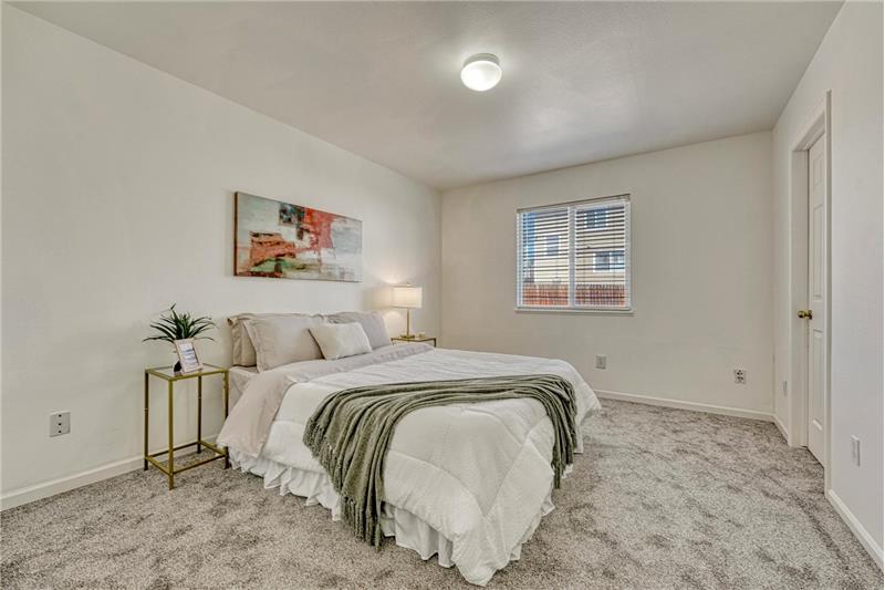 Primary Bedroom with new carpet, a walk in closet, and adjoining bathroom.