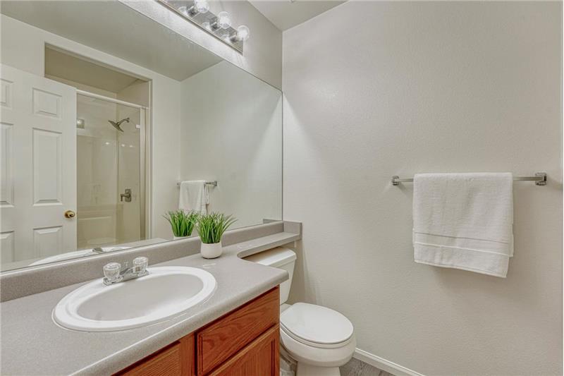Primary Shower Bathroom with vanity, mirror, and tiled shower.