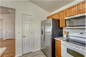 Stainless steel refrigerator, smooth top range/oven, and built-in microwave.
