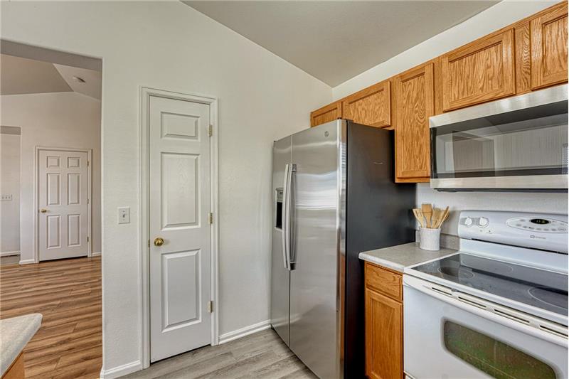 Stainless steel refrigerator, smooth top range/oven, and built-in microwave.