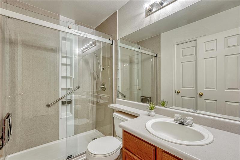 Shower Bathroom with vanity, mirror, and tiled shower.