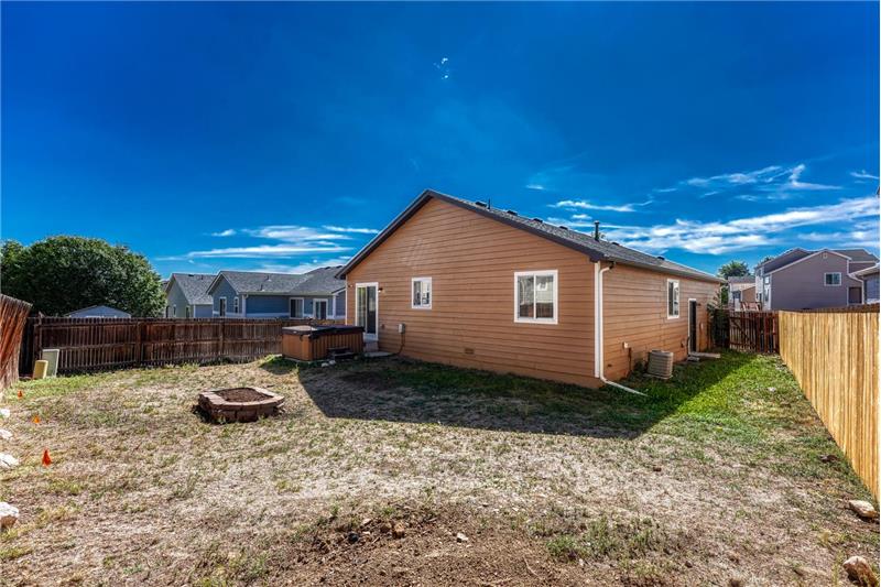 Rear view of home and fenced backyard.