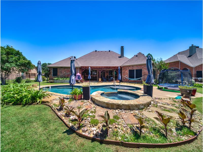 Backyard features beautiful pool with a spa