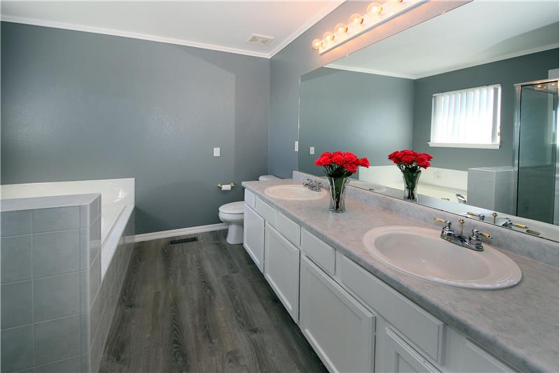 Master bathroom with new flooring and paint, crown moulding, and double sink vanity.
