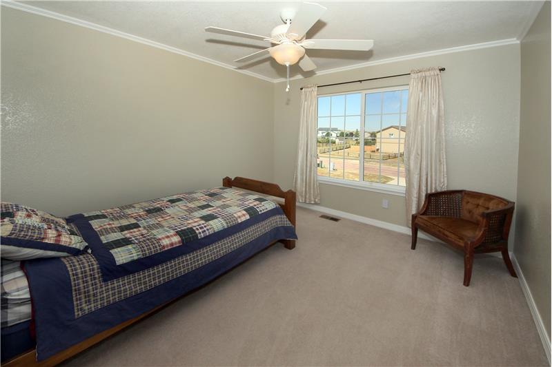 Bedroom 2 with ceiling fan and crown moulding