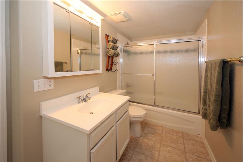 Full bathroom with tile flooring in basement