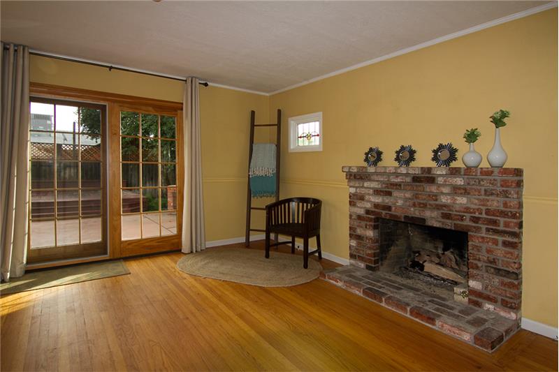 Cozy fireplace & sliding french doors to the back yard