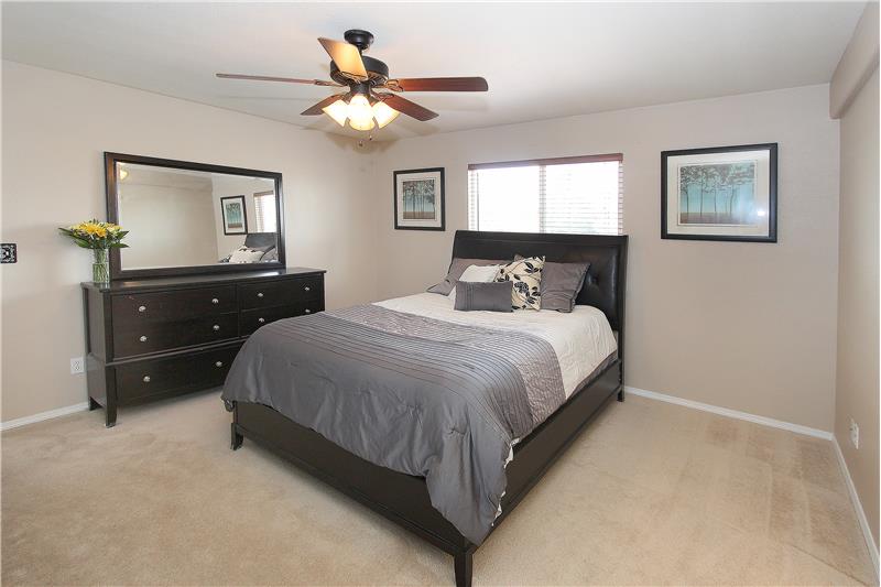 Spacious master bedroom with ceiling fan