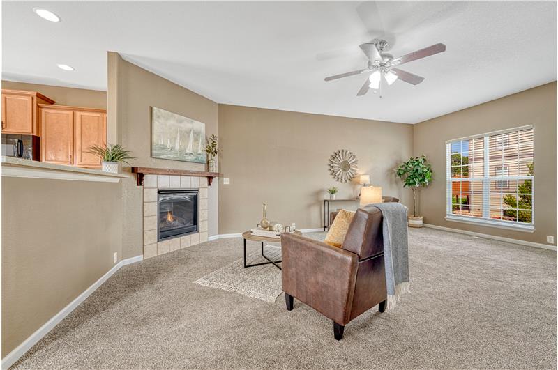 Living room with gas log fireplace and lighted ceiling fan