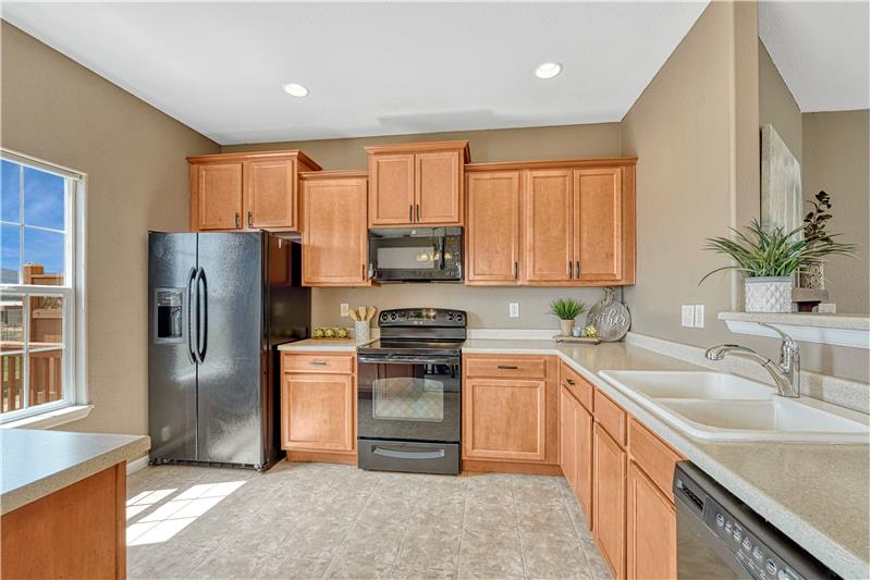 Bright and functional kitchen with ample cabinet storage, counter top space, included appliances, and pantry