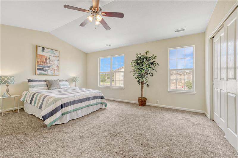 One of two Primary Bedrooms on Upper Level with adjoining full bath, vaulted ceilings, and lighted ceiling fan