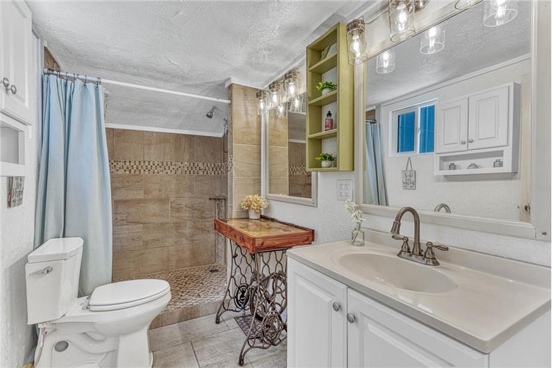 Completely updated bathroom on main level with a large tiled shower with bench and shelves!