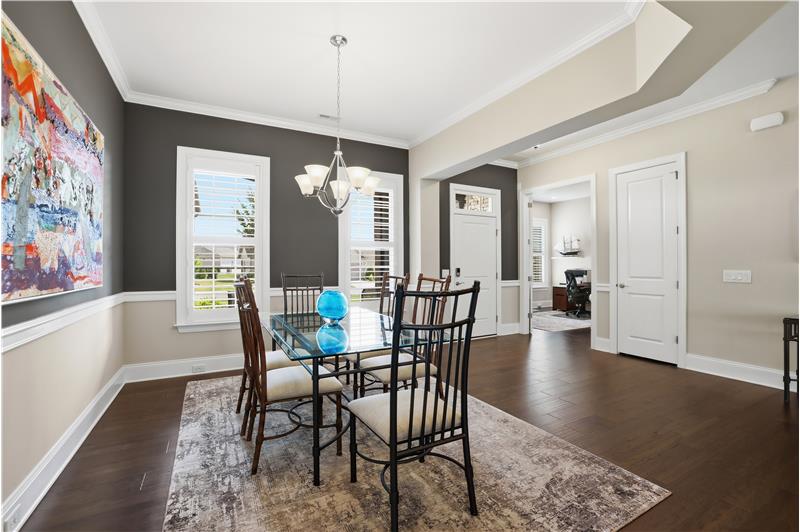 Dining room combines comfort and sophistication with dramatic accent walls, rich millwork. Host family and friends in style.