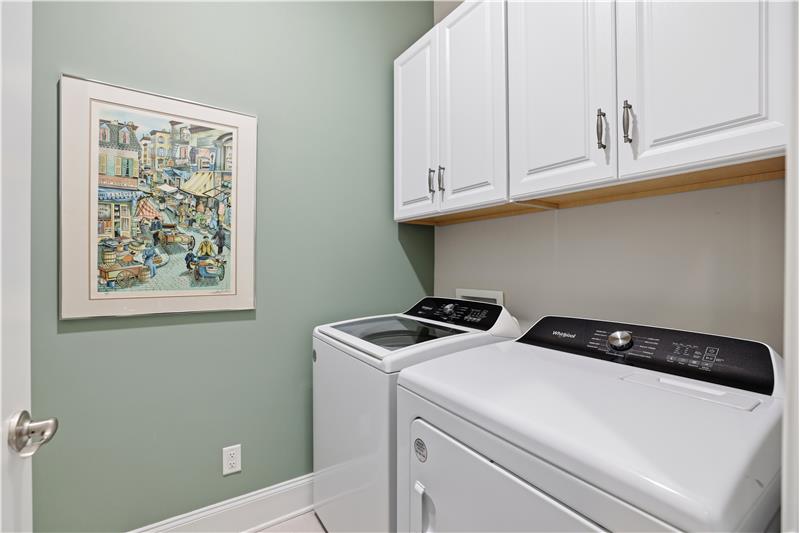 Laundry room with storage cabinets. There's also a utility sink with a storage cabinet above it.