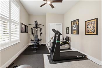 One of two secondary bedrooms in this split bedroom plan home, currently used as a home gym.