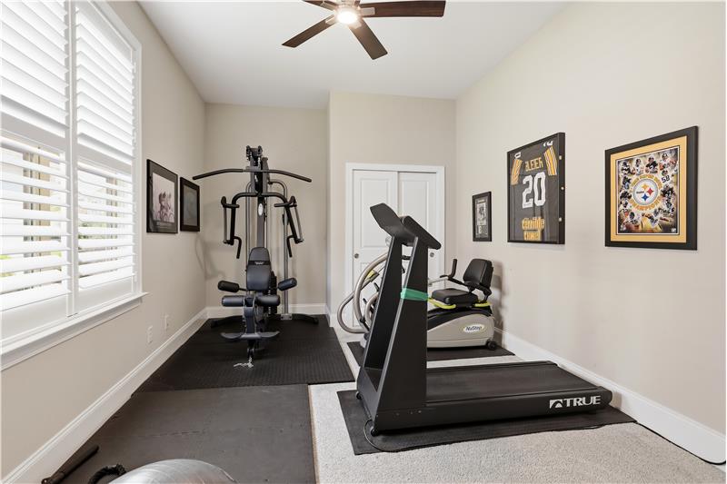 One of two secondary bedrooms in this split bedroom plan home, currently used as a home gym.