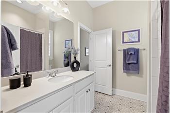 Jack & Jill bathroom with custom tile flooring shared by the home's two secondary bedrooms.