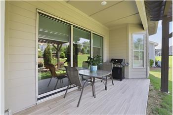 Covered back patio with space for grilling, al fresco dining is a natural extension of the home's living and entertaining areas.