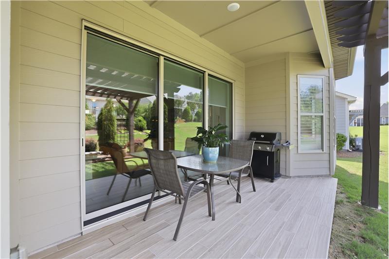 Covered back patio with space for grilling, al fresco dining is a natural extension of the home's living and entertaining areas.