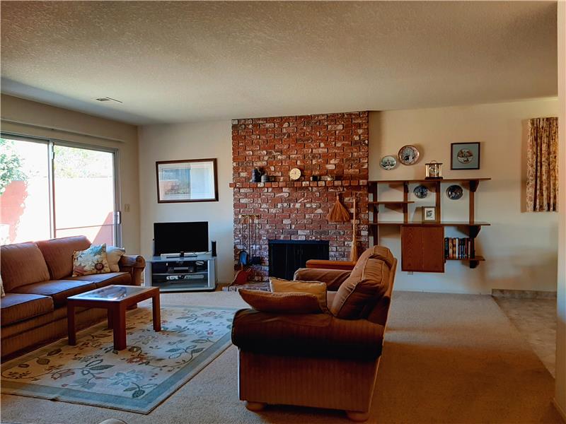 Classic Brick Wood Burning Fireplace is the Centerpiece of the Living Room.