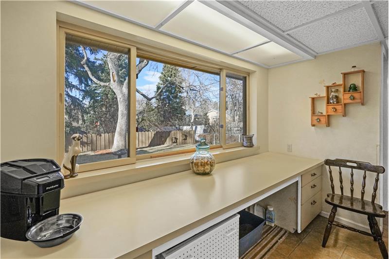 Folding table in laundry room with window to backyard