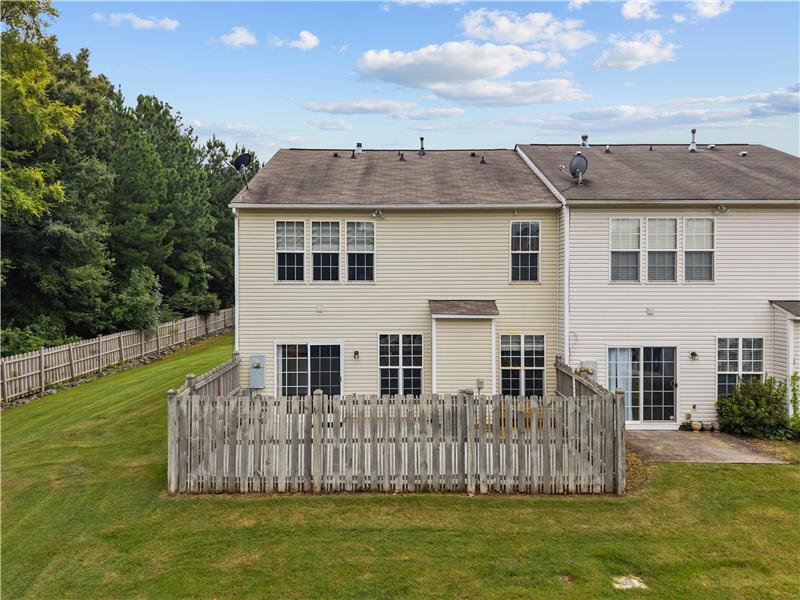 Back view of townhome and fenced patio.