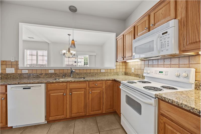 Kitchen features granite counters and a pass through to the dining room.