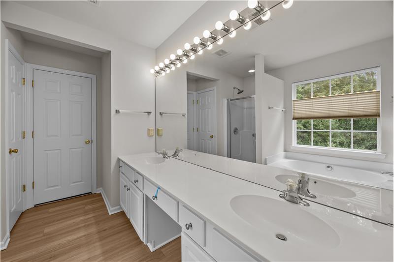 Primary bathroom features extended, dual sink vanity, new flooring, separate tub and shower, walk-in closet, private WC..