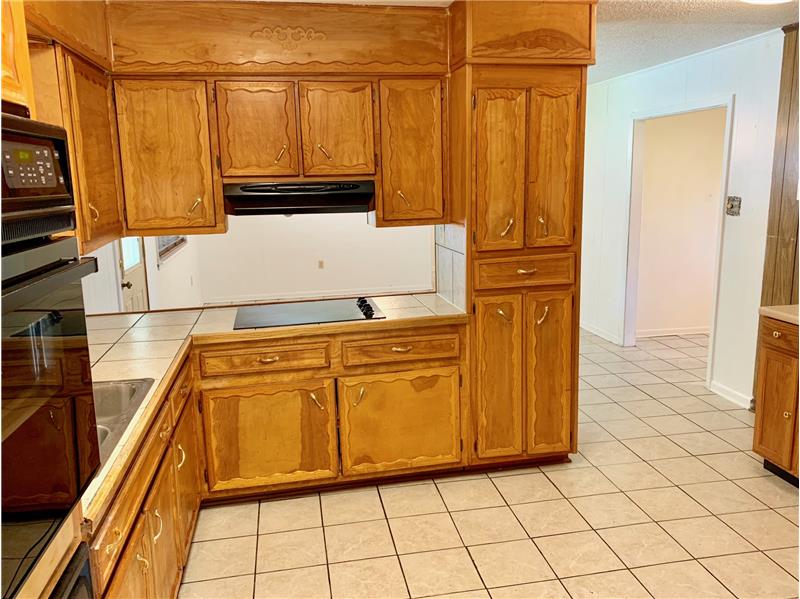 Kitchen features tile countertops, tons of cabinet storage