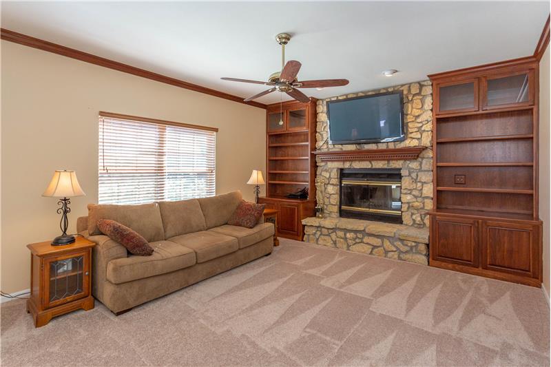 Great room with stone fireplace, gas starter & custom built cabinets flanking the fireplace - 12915 Whitehaven Ln