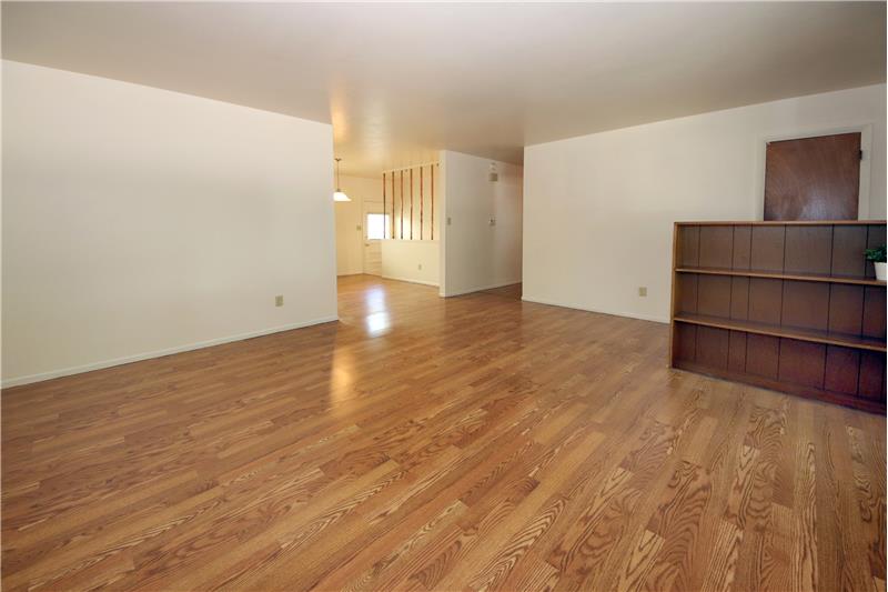 Living room hardwood flooring, coat closet, and with built-in bookcases