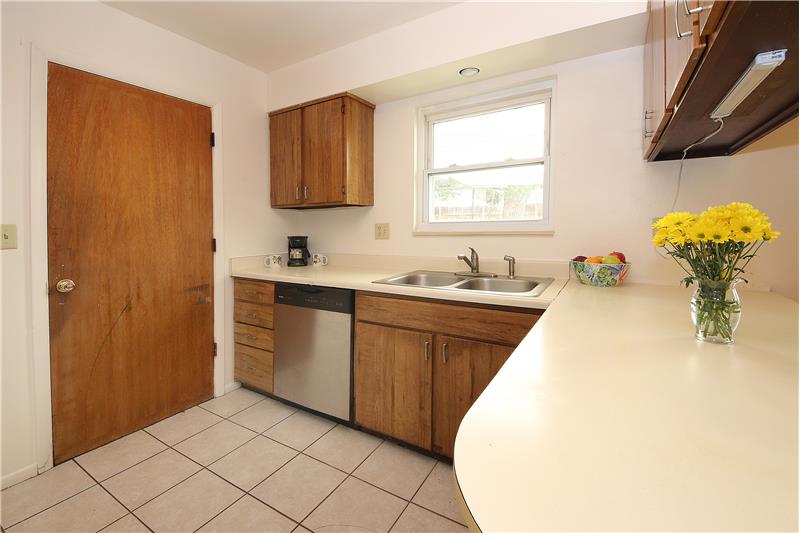 Kitchen with tile flooring, sturdy cabinets, and a breakfast bar