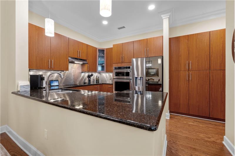 Kitchen features granite counters, stainless steel appliances, tile backsplash, ample cabinet and counter space