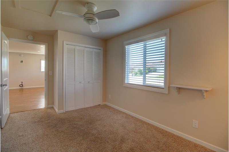 Light & bright North facing Bedroom 1 with ceiling fan and wall sconces.