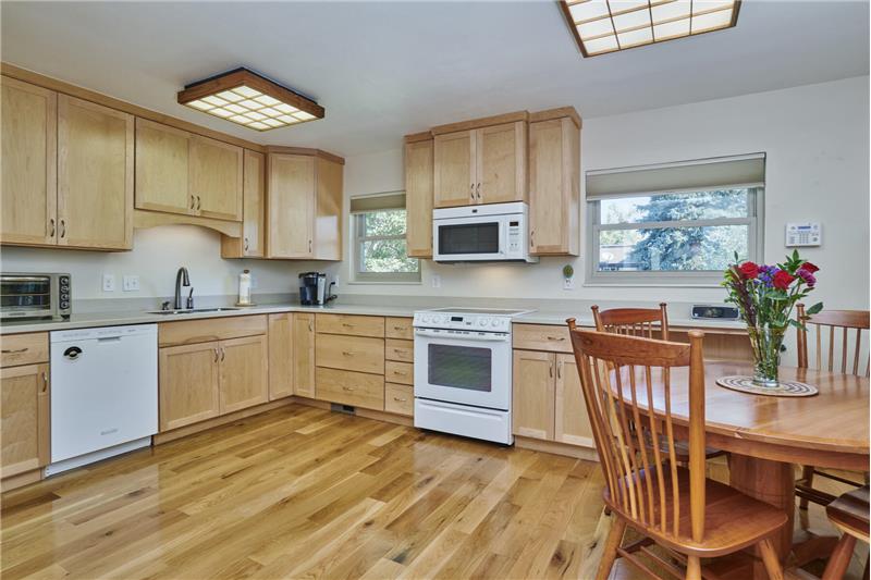 Eat-in kitchen with hardwood floor and Corian counters