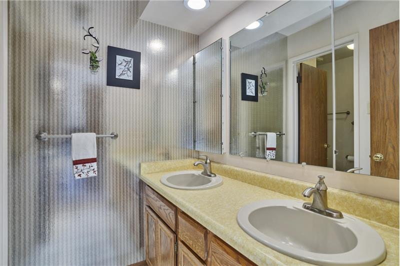 Hallway bathroom with double vanity and separate room for toilet and bath/shower