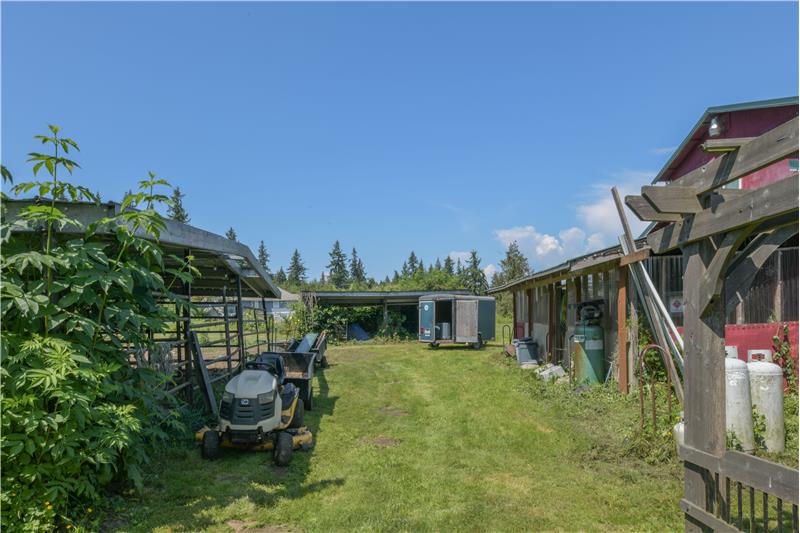 In between horse structure and back of horse barn/dwelling