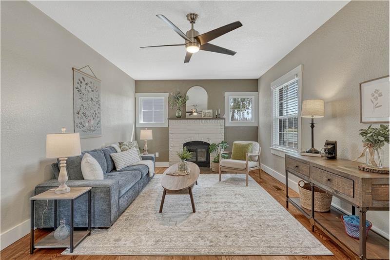 iving room with wood burning fireplace and ceiling fan