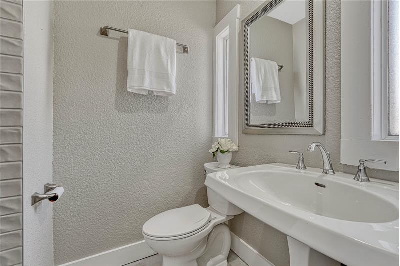 Main level 3/4 bath with pedestal sink and tiled shower