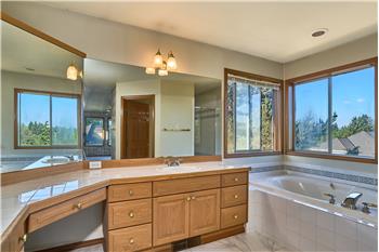 Immaculate 5 Piece Primary Bathroom with Dual Sinks, Soaking Tub, Tile Countertops and Tile Flooring.