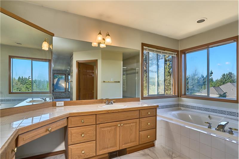 Immaculate 5 Piece Primary Bathroom with Dual Sinks, Soaking Tub, Tile Countertops and Tile Flooring.